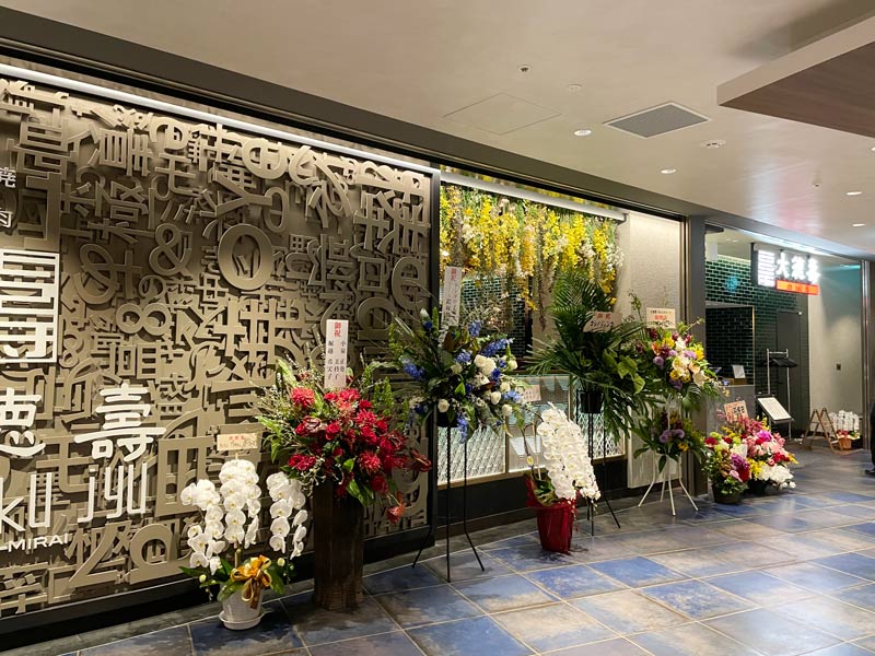 桜木町コレットマーレ7階レストランフロアにオープンした「大徳壽みなとみらい店」に並ぶ開店祝い花の写真